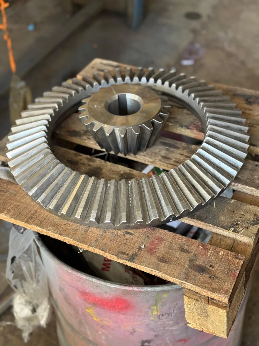 Engranaje cónico de 800 mm y su piñón sobre pallet industrial, fabricados en acero SAE 4140
