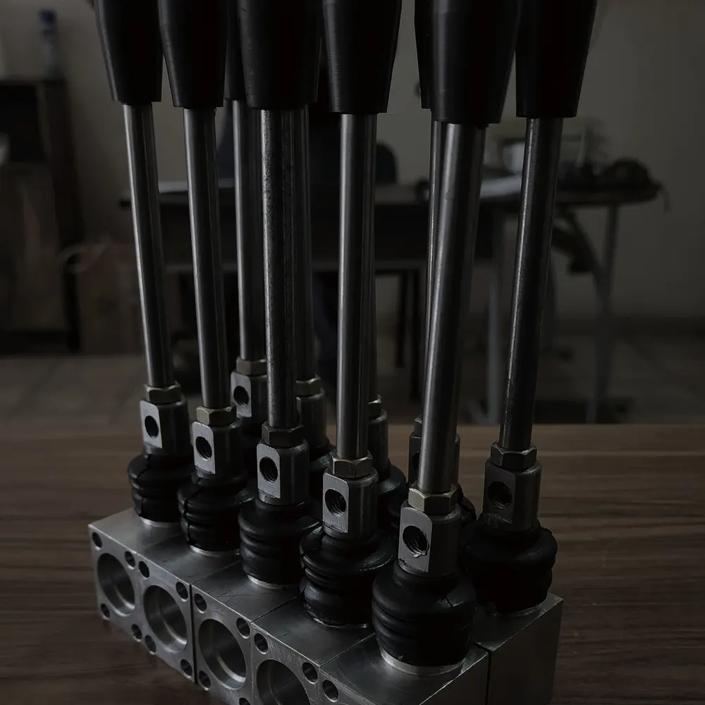 Serie de cuerpos de valvula hidraulica mecanizados en CNC con vastagos y perillas